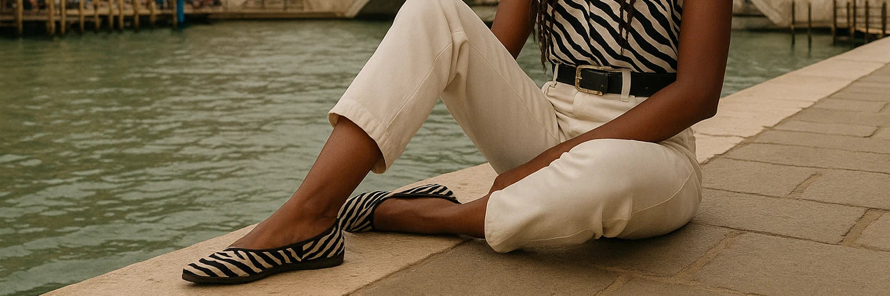 Chica sentada a la orilla del río con venecianas de zebra